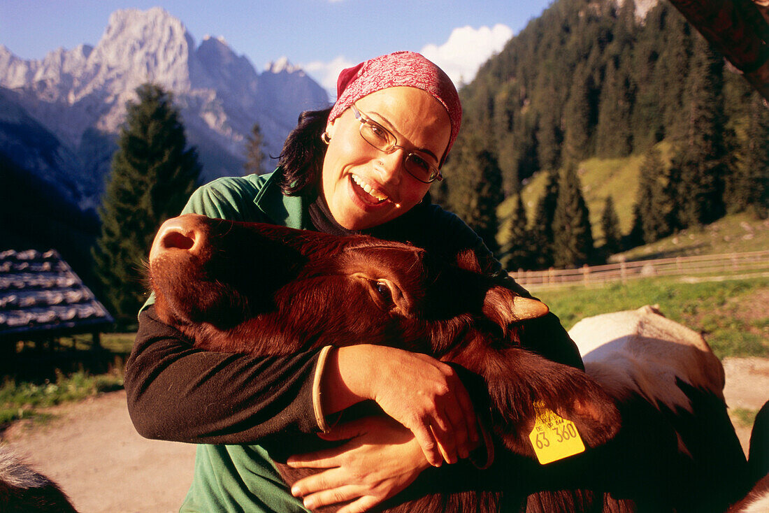 Dairymaid embracing calf, Bindalm, Berchtesgaden National Park, Berchtesgadener Land, Upper Bavaria, Germany