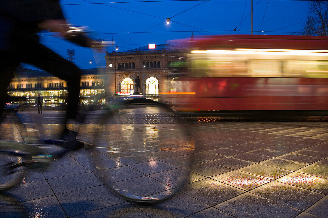 Tram and cyclist passing railway station forecourt, Hanover central station, Lower Saxony, Germany