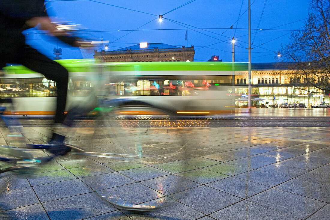 Tram and cyclist passing railway station forecourt, Hanover central station, Lower Saxony, Germany