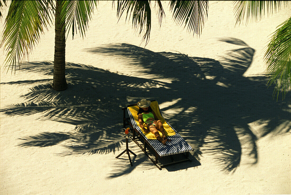 Frau am Strand im Schatten einer Palme, Badian Island, Cebu, Philippinen