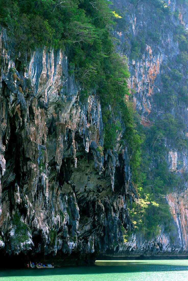 Fischerboot unter überhängendem Kalkseinelsen, Bucht von Phang Nga, Thailand