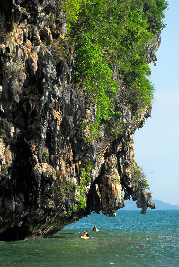 Kajak unter überhängendem Kalksteinfelsen, Bucht von Phang Nga, Thailand