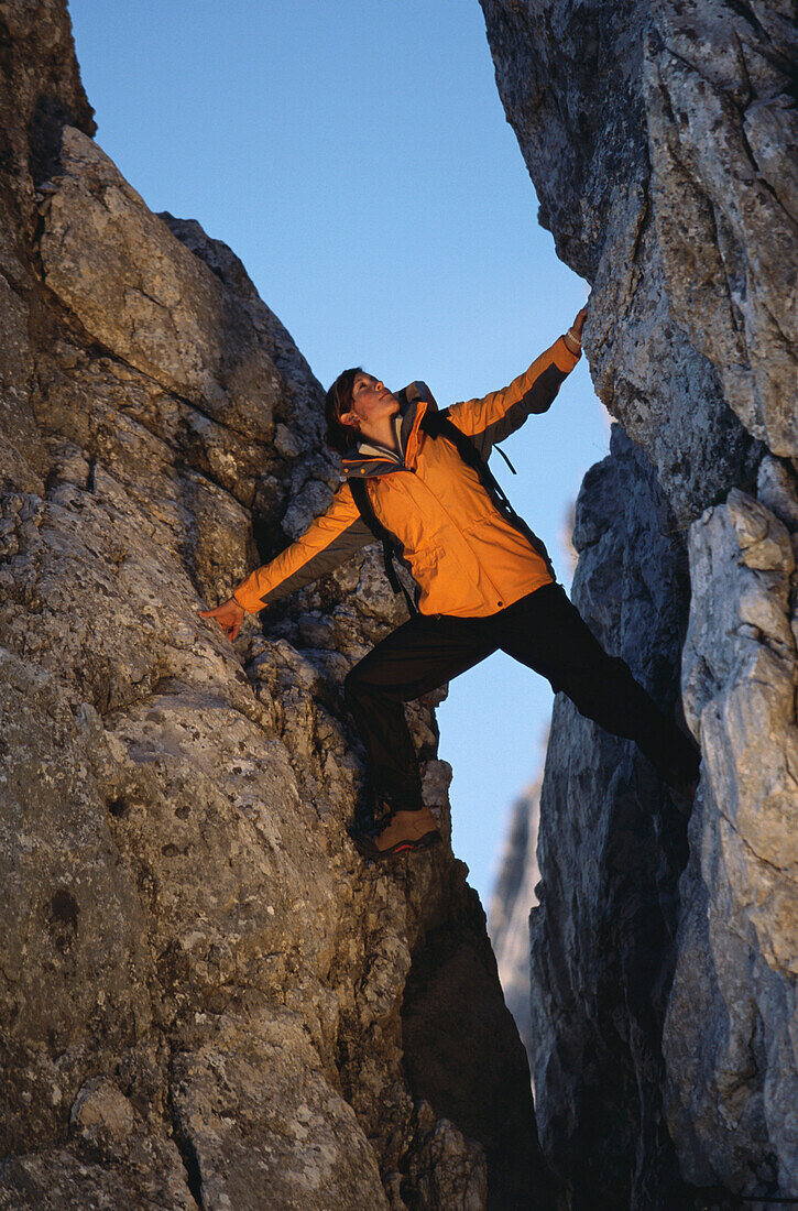 Frau klettert in einer Felsspalte, Alpspitze, Garmisch-Partenkirchen, Bayern, Deutschland