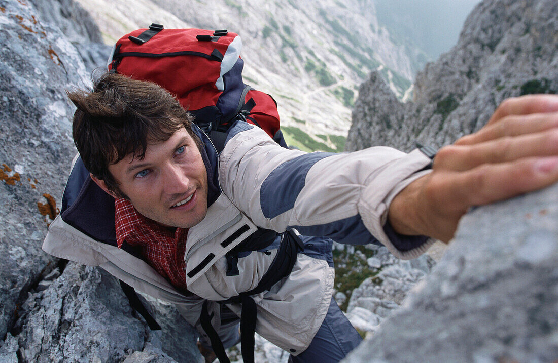 Mann klettert auf Alpspitze, Garmisch-Partenkirchen, Bayern, Deutschland
