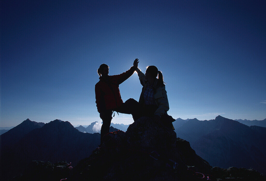 Two people arriving Dammkar summit, Mittenwald, Bavaria, Germany