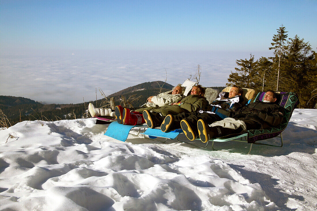 Familie nimmt Sonnenbad imWinter, Hornisgrinde, Schwarzwald, Deutschland