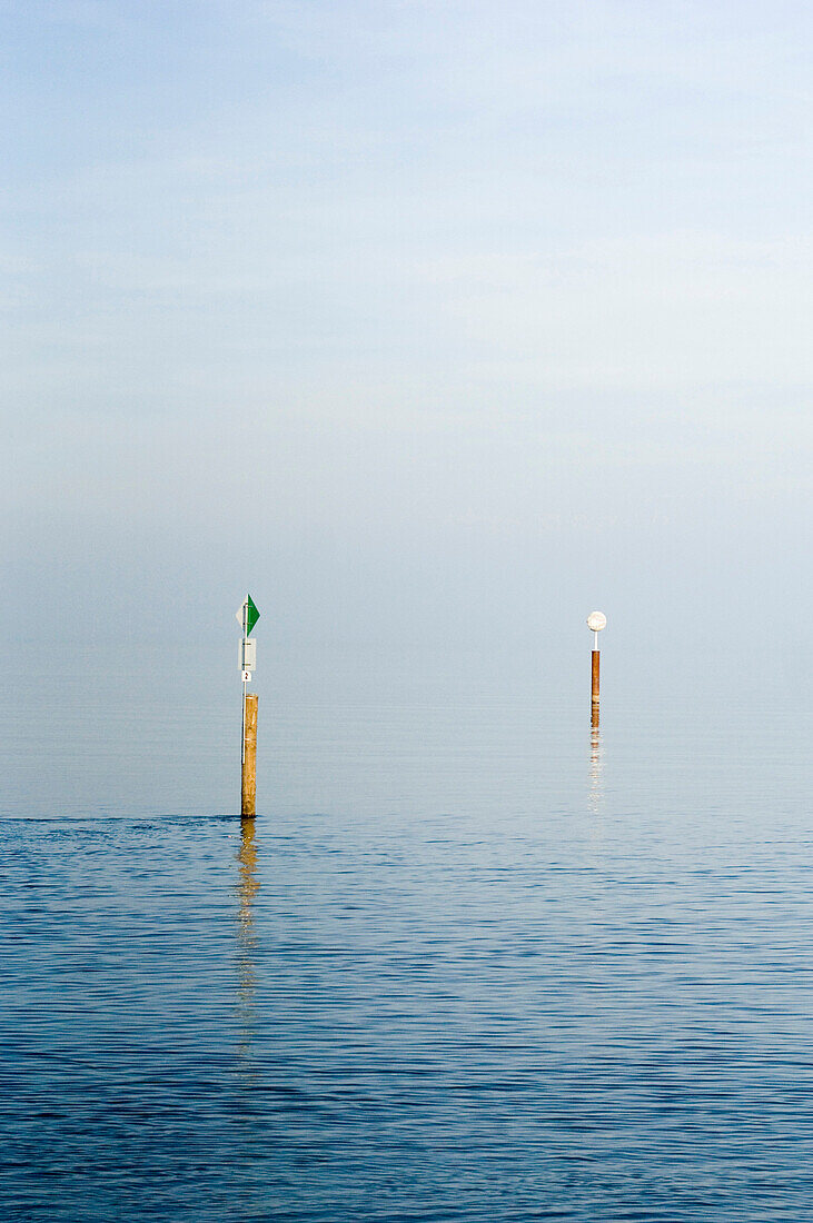 Two poles in the water at lake Bodensee, Constance, Baden-Wuerttemberg, Germany