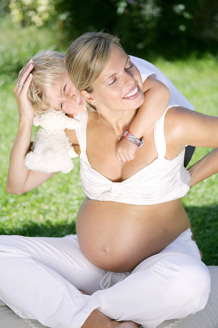 Boy (4-5 years) embracing pregnant mother from behind, Styria, Austria