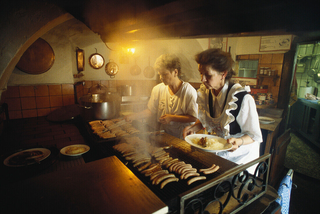 Two female cooks inside the Historical Sausage Kitchen, Historische Wurstküche, Regensburg, Bavaria, Germany
