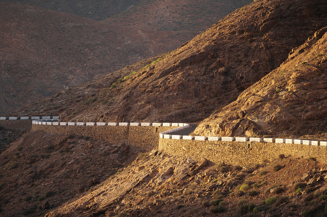 Einsame Landstraße schlängelt sich durch karge Landschaft, Fuerteventura, Islas Canarias, Kanarische Inseln, Spanien