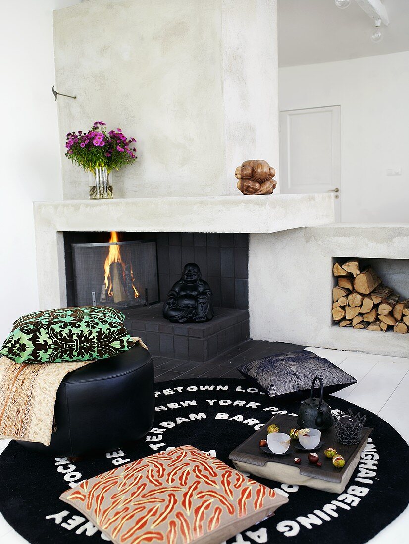 Tea break with pillows on a rug in front of a fireplace