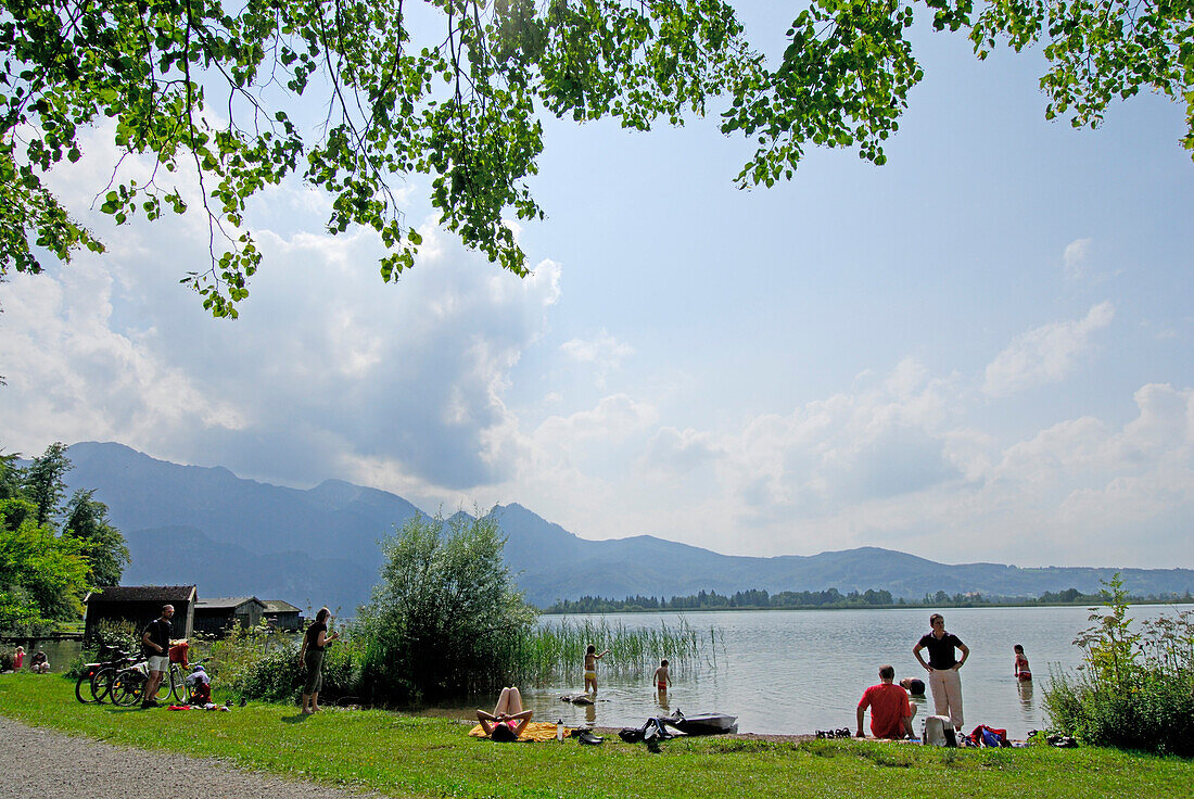 bathers at shore of lake Kochelsee, Bavarian Alps in background, Upper Bavaria, Bavaria, Germany