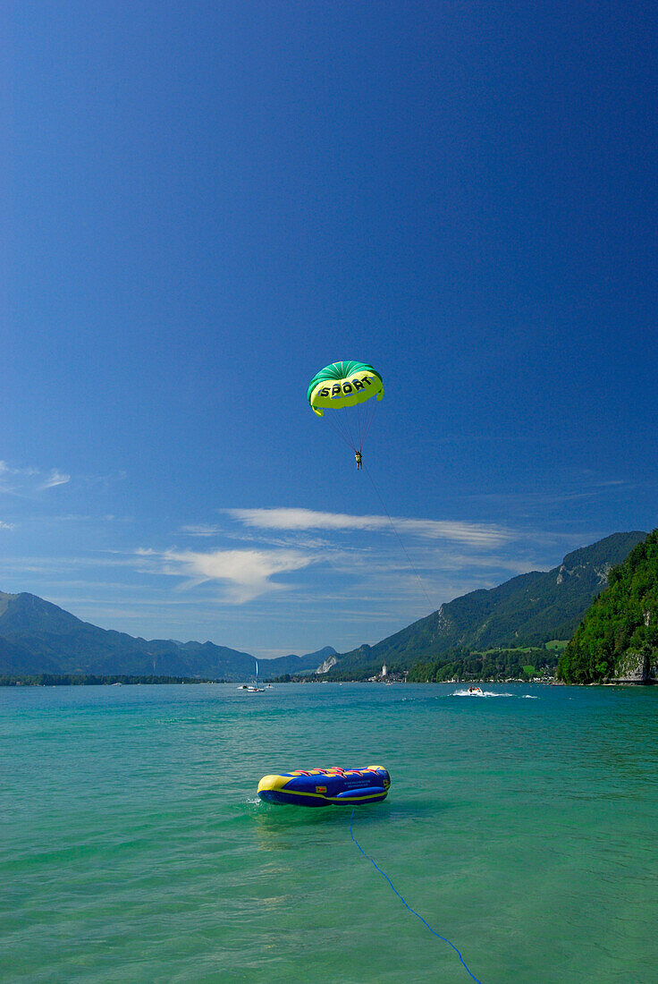 Young woman parasailing, lake Abersee (lake Wolfgangsee), Salzkammergut, Salzburg, Austria