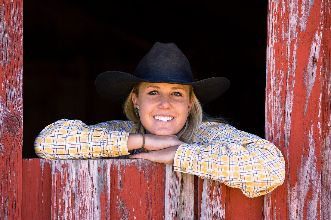 Cowgirl schaut aus Scheunenfenster, Wilder Westen, Oregon, USA