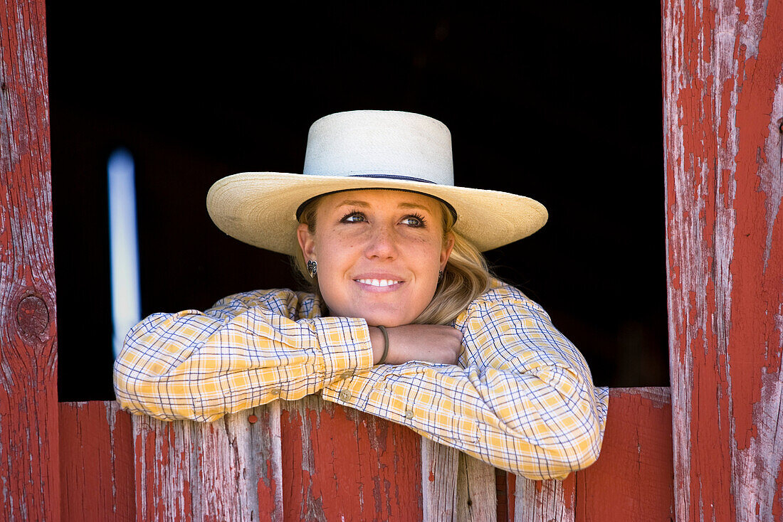 Cowgirl looking out of barn-window, wildwest, Oregon, USA