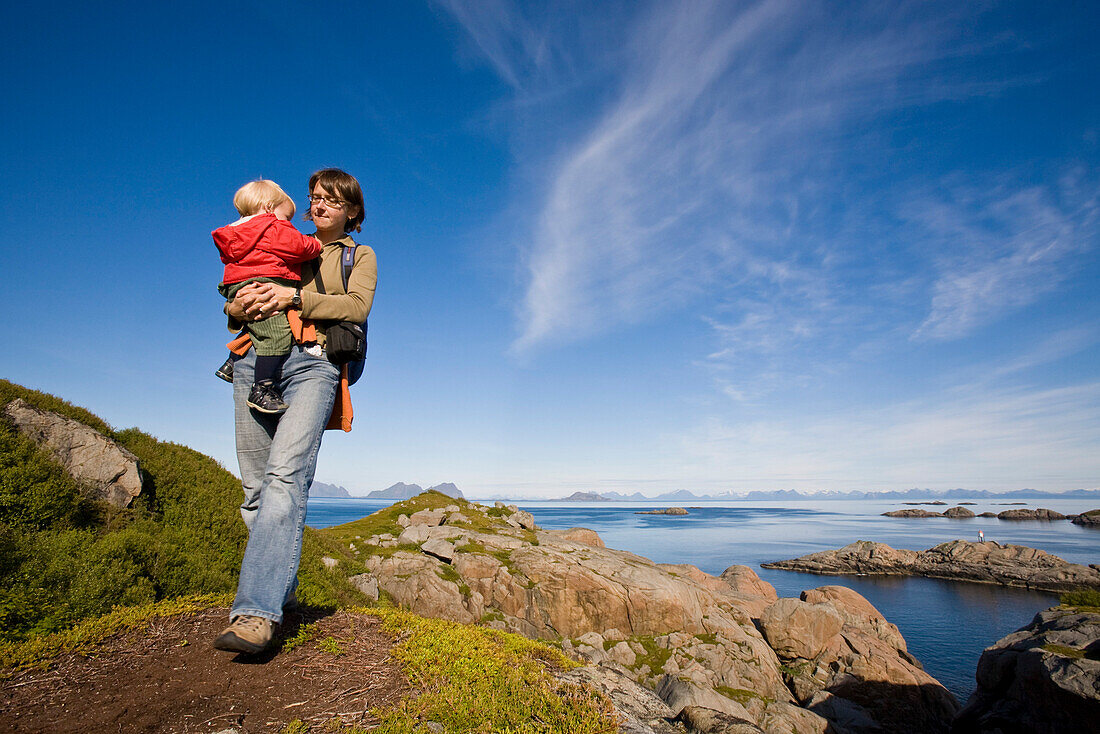 Mother carrying child, Skerry coast of Kalle, Austvagoya Island, Lofoten, Norway