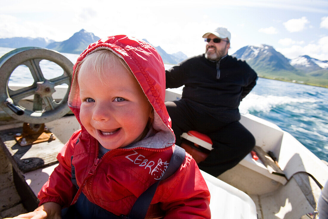 Kleines Mädchen, Kleinkind, und Mann auf einem Fischerboot vor Hadselsand, Insel Austvagoya, Lofoten, Norwegen