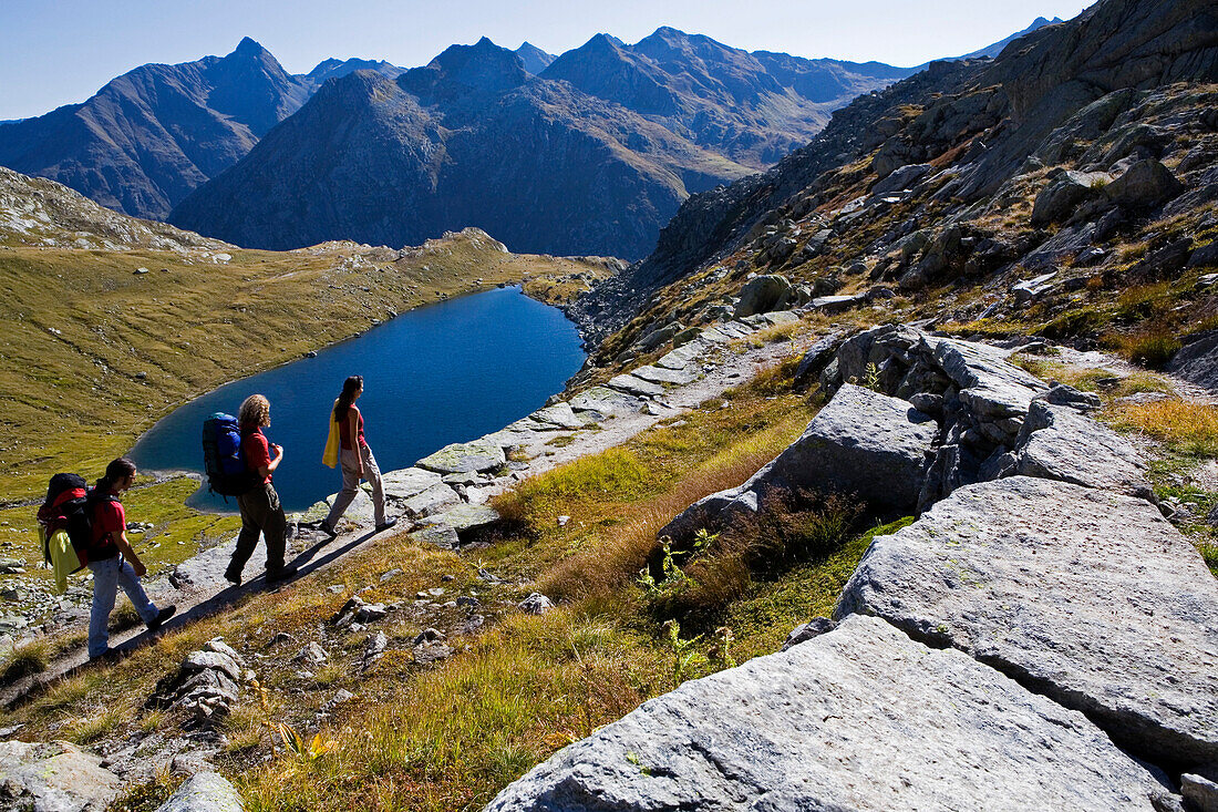 Three young people hiking, Lago d'Orsino, Gotthard, Canton of Ticino, Switzerland