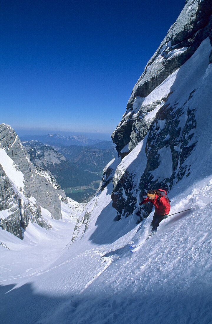 Junge Frau bei rasanter Pulverschneeabfahrt vom Hochkalter, Blaueis, Berchtesgadener Alpen, Oberbayern, Bayern, Deutschland