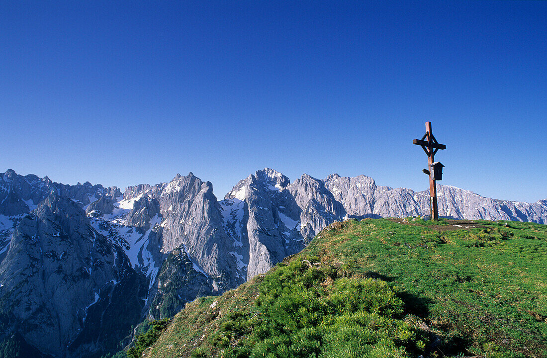 Summit cross on mount Feldberg, view to Wilder Kaiser range and Steinerne Rinne, Kaiser range, Tyrol, Austria