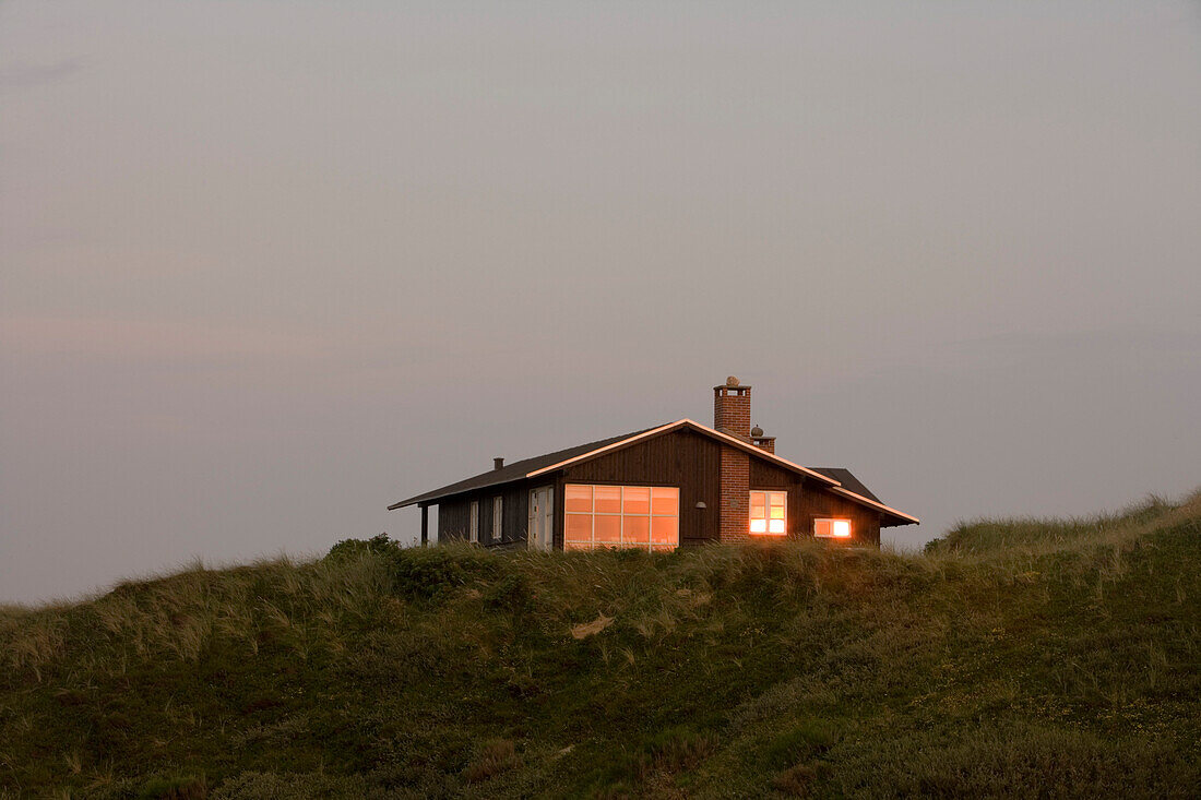 Sonnenuntergang spiegelt sich in Fenstern von Ferienhaus, Henne Strand, Jütland, Dänemark, Europa
