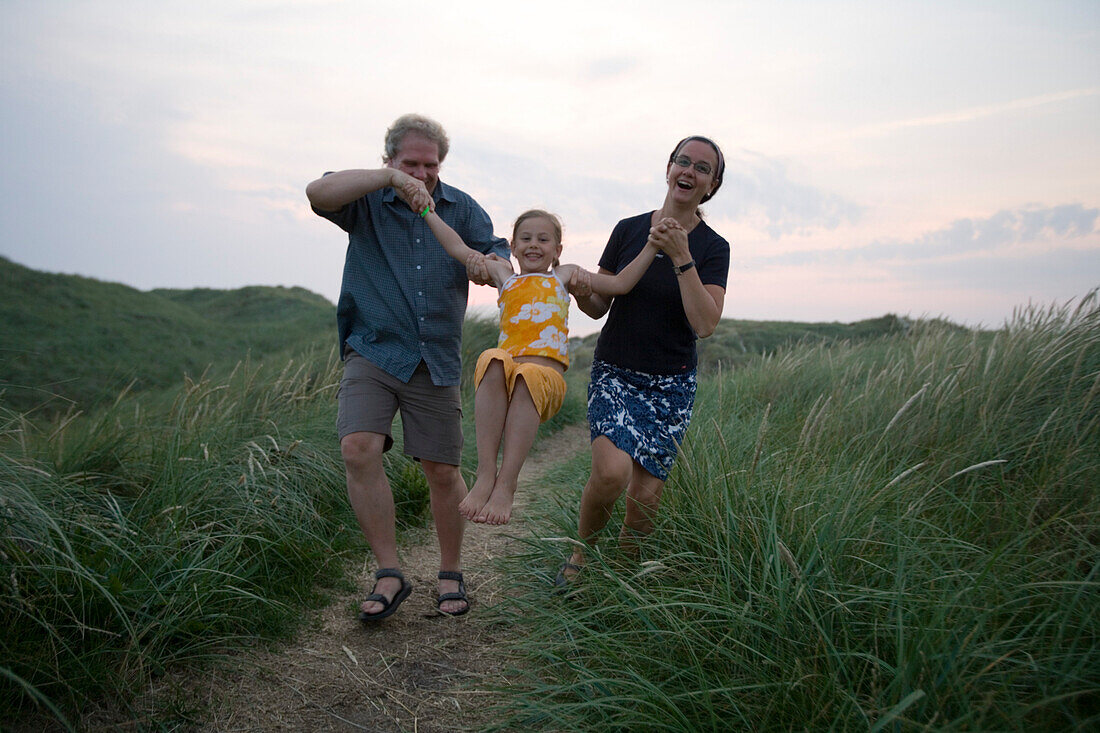 Vergnügte Familie bei Lauf durch Dünen, Henne Strand, Jütland, Dänemark, Europa