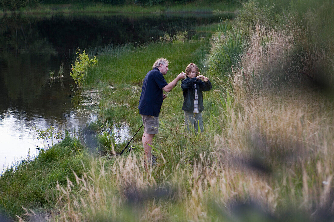 Vater und Sohn beim Angeln am See, nahe Henne, Jütland, Dänemark, Europa