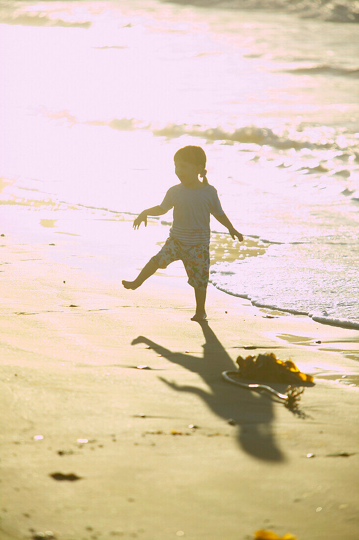 Mädchen (2-3 Jahre) tanzt am Strand in Sonnenuntergang, Insel Spiekeroog, Ostfriesische Insel, Niedersachsen, Deutschland