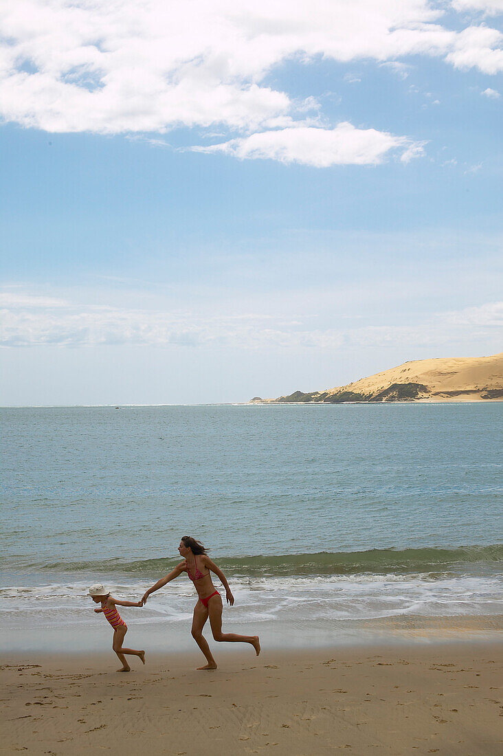 Mother and daughter playing on Opononi beach, sand dunes, protected Hokianga Harbour, Northland, North Island, New Zealand