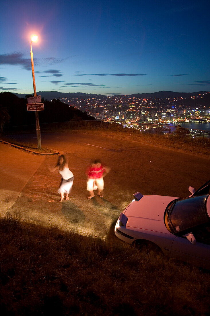 Polynesian girls from Samoa dancing to music from their car. Friday night on Mt. Victoria. Overlooking citycentre of Wellington, North Island, New Zealand