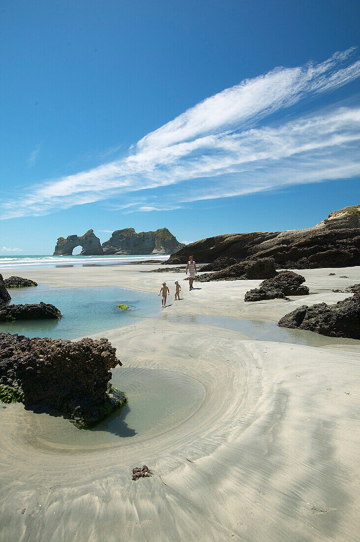 Hiking on Wharariki Beach, tidal pools, low tide, near Puponga, northwestern coast of South Island, New Zealand