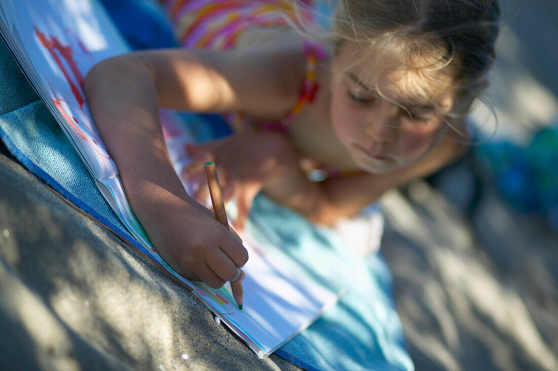 Girl (5 years) drawing a picture, Spiekeroog island, East Frisian Islands, Lower Saxony, Germany