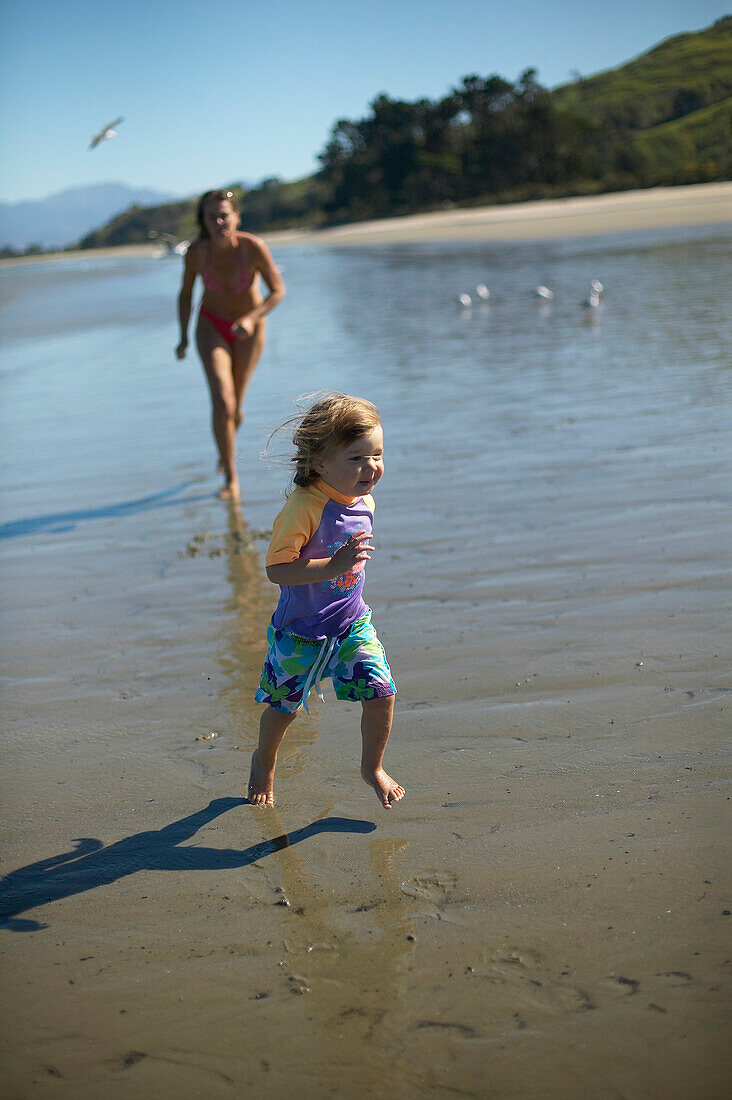 Mother and daughter playing at Pakawau beach, Golden Bay, northern coast of South Island, New Zealand