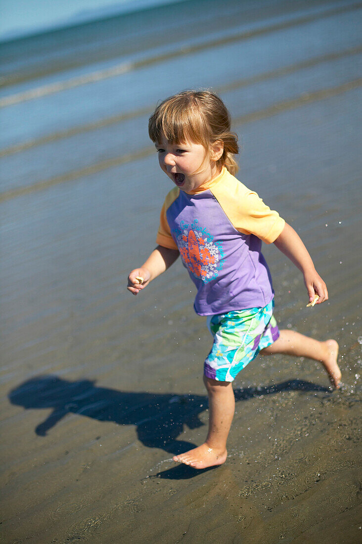 Girl (2 years) running along beach Kniepsand, Wittduen, Amrum island, North Frisian Islands, Schleswig-Holstein, Germany