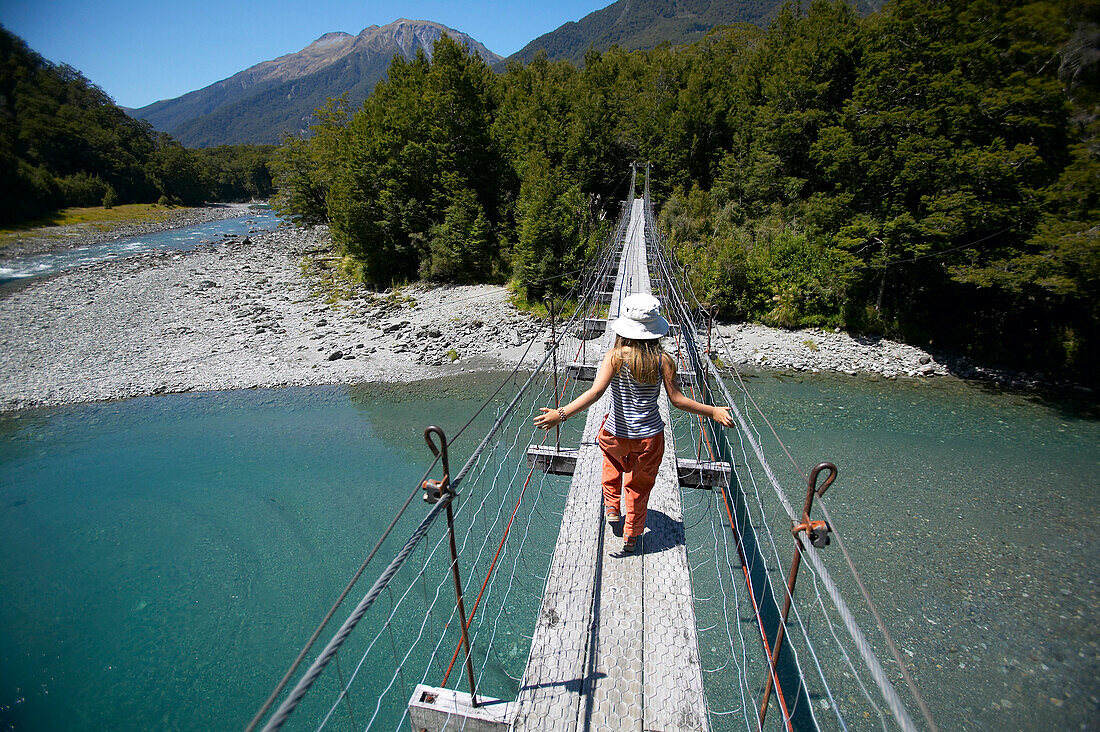 Girl on hanging bridge, track to Blue Pools, east of  Haast Pass, Southern Alps, South Island, New Zealand