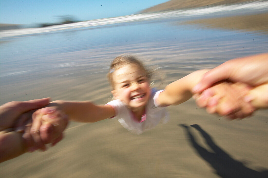 Mädchen (5 Jahre alt) fliegt durch schnelles drehen, Strand der Okains Bay, Bank's Peninsula, Ostküste, Südinsel, Neuseeland