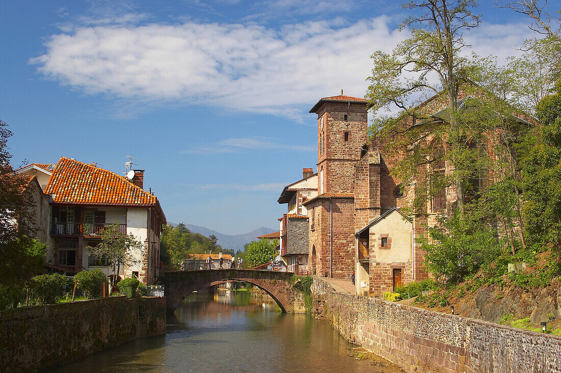 Old stone bridge over the river Nive with church in the background, St. James Way, St. Jean-Pied-de-Port, Pyrenees, Dep. Pyrénées-Atlantiques, France