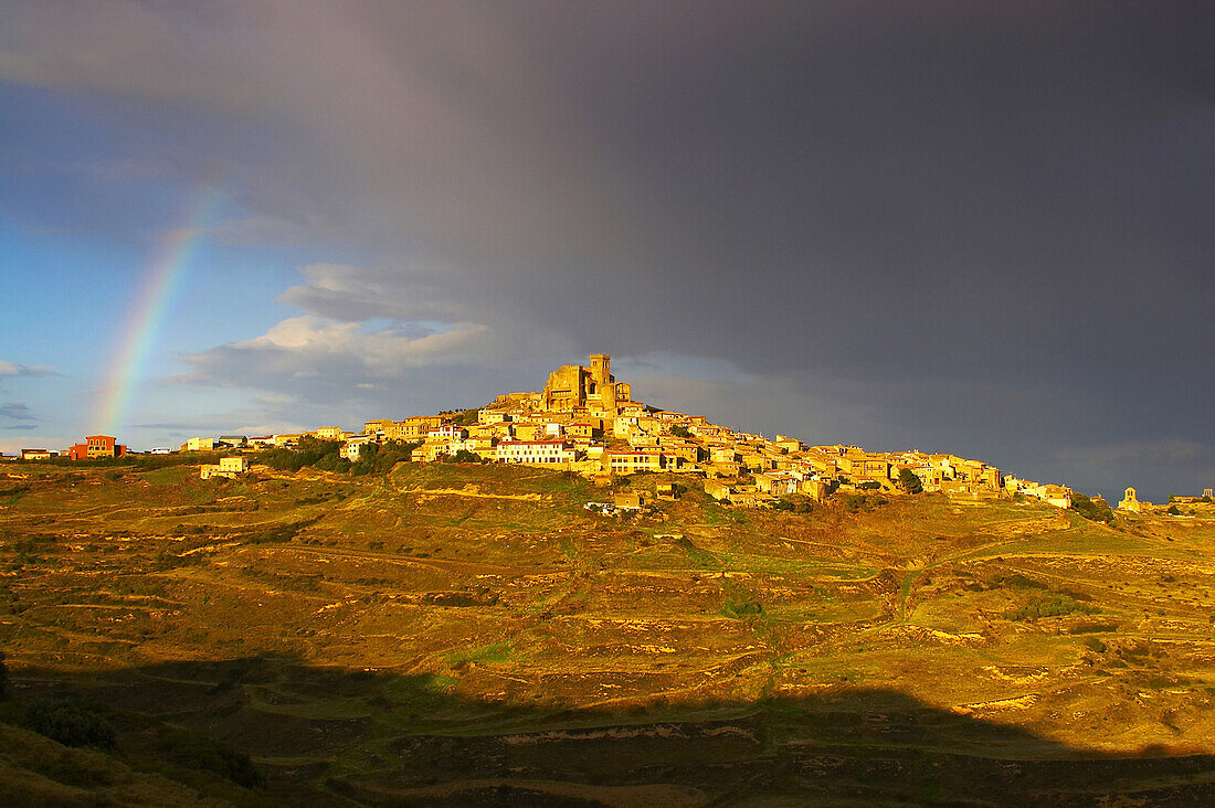 Landscape with rainbow and dramatic sky after a thunderstorm, small town on top of a mountain, UjueLands, Navarra, Spain