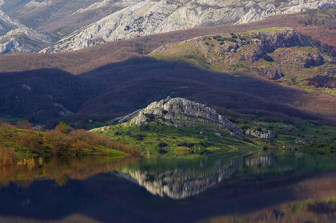 Landscape of a reservoir with reflection, Embalse de Porma, snow covered mountains in the background, Codillera Cantabrica, Castilla León, Spain