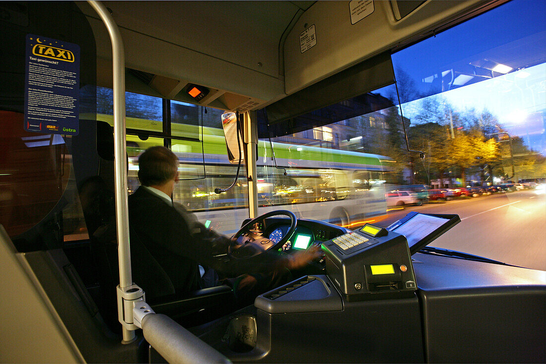 öffentlicher Nahverkehr Hannover, Silberpfeilbus, Blick aus dem Bus über den Fahrer auf die beleuchtete Strasse in der List