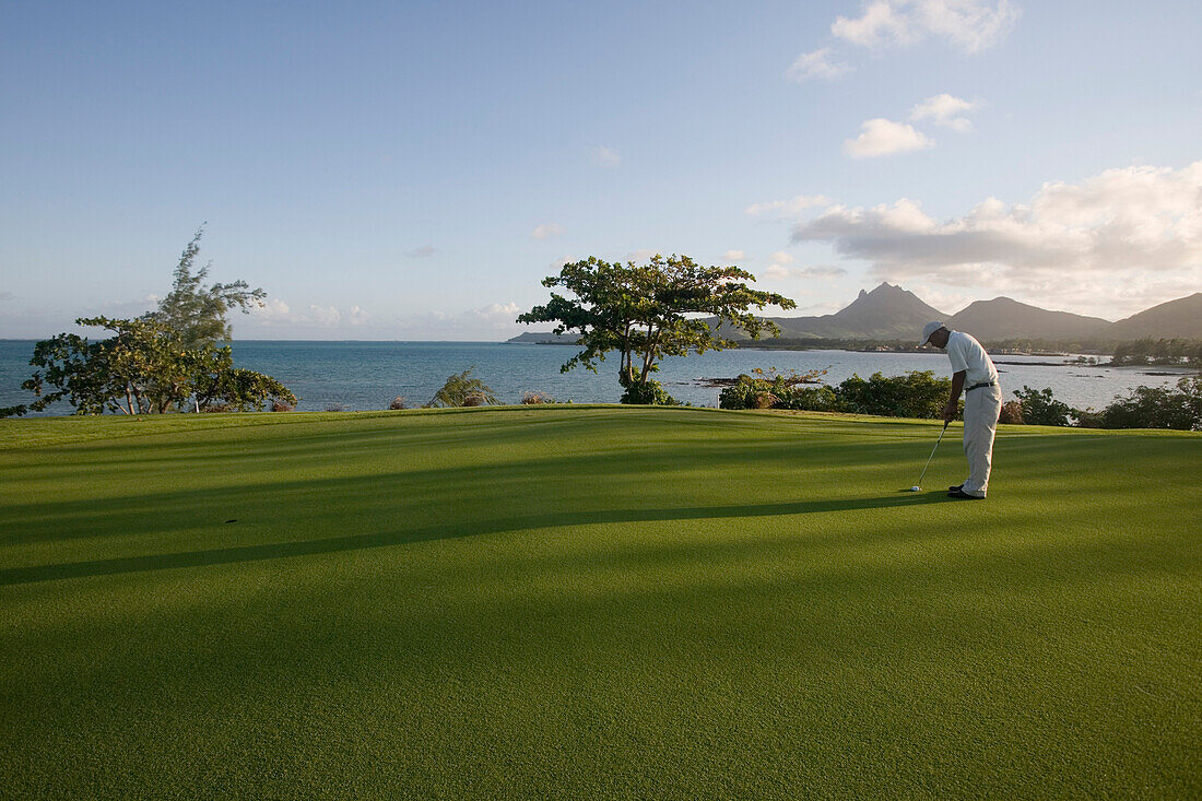 Golfer am Grün des 11. Loch Round the Bend am Le Touessrok Golfplatz, Insel Ile aux Cerfs, nahe Trou d'Eau Douce, Flacq District, Mauritius, Indischer Ozean