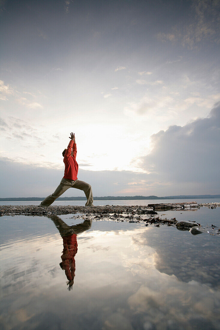 Man practising yoga at Lake Starnberger, Muensing, Bavaria, Germany, MR