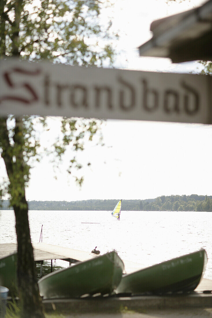 Grüne Ruderboote, Strandbad Raabe, Windsurfer im Hintergrund, Wörthsee, Bayern, Deutschland