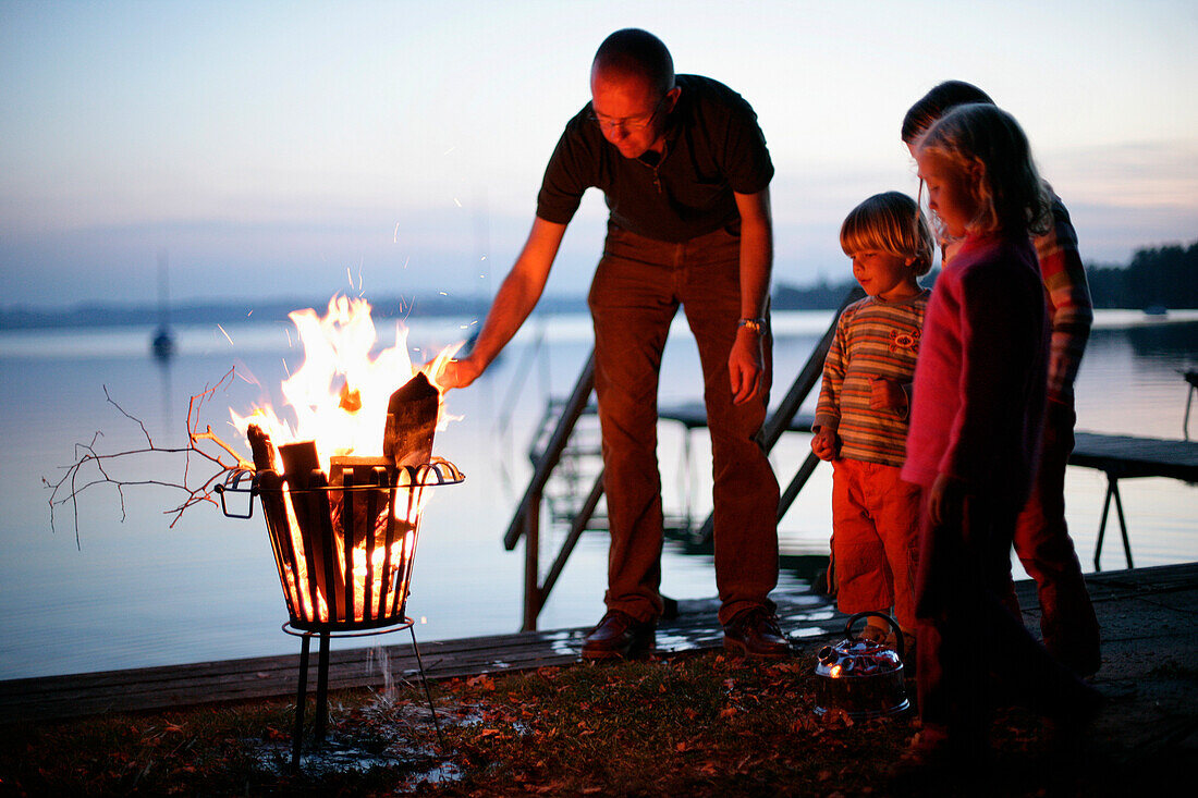 Man and children at campfire, Lake Woerthsee, Bavaria, Germany, MR