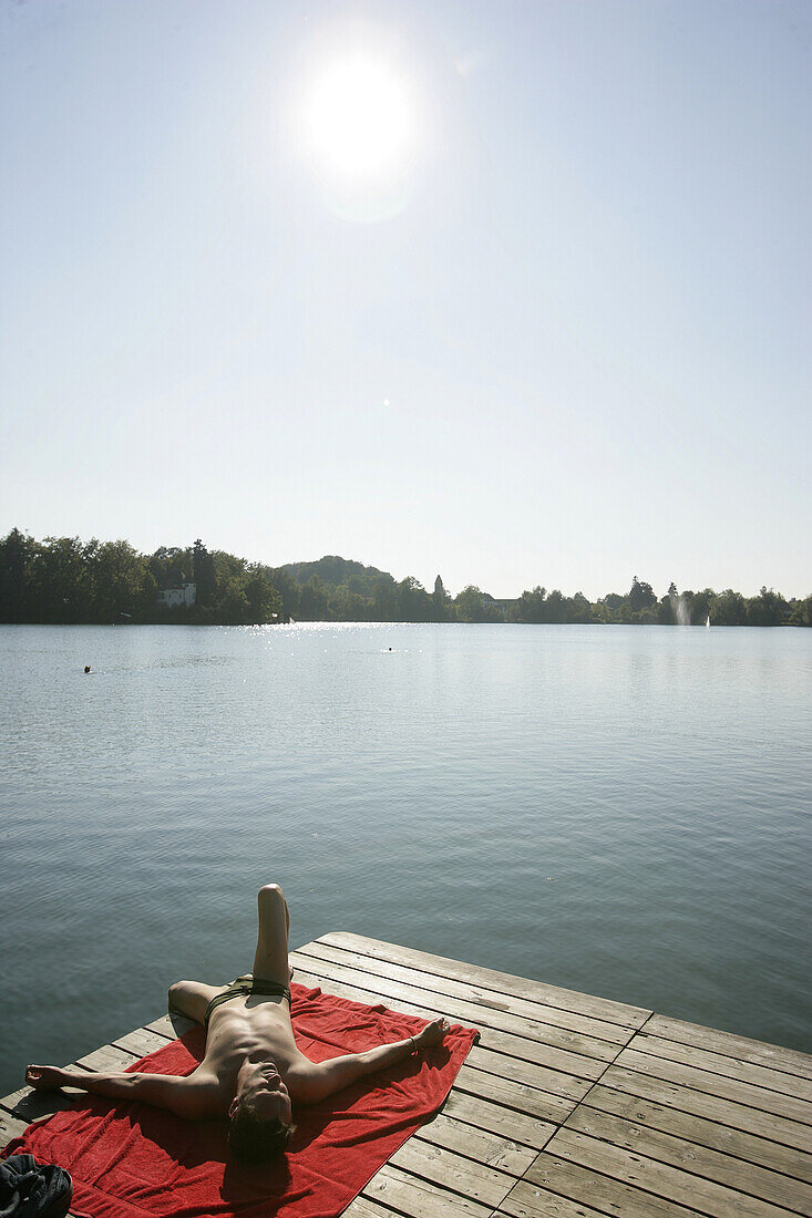 Mann beim Sonnenbaden auf einem Holzsteg, Weßlinger See, Oberbayern, Bayern, Deutschland