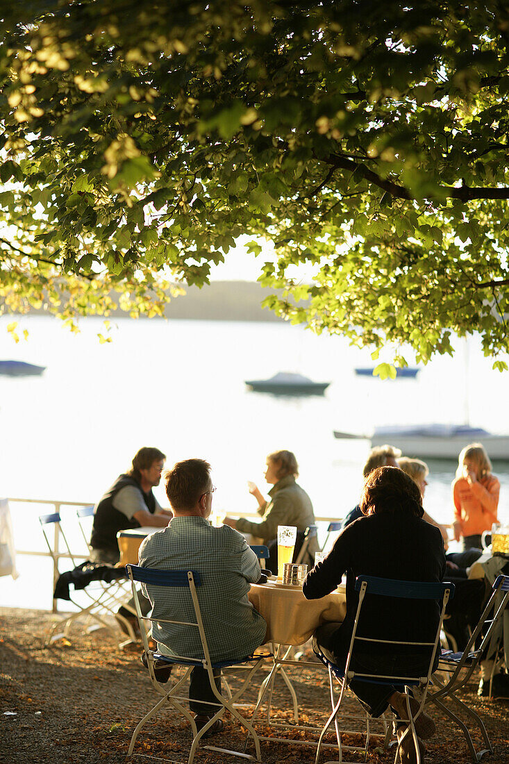 Leute sitzen im Biergarten vom Restaurant Woerl am Wörthsee, Bayern, Deutschland