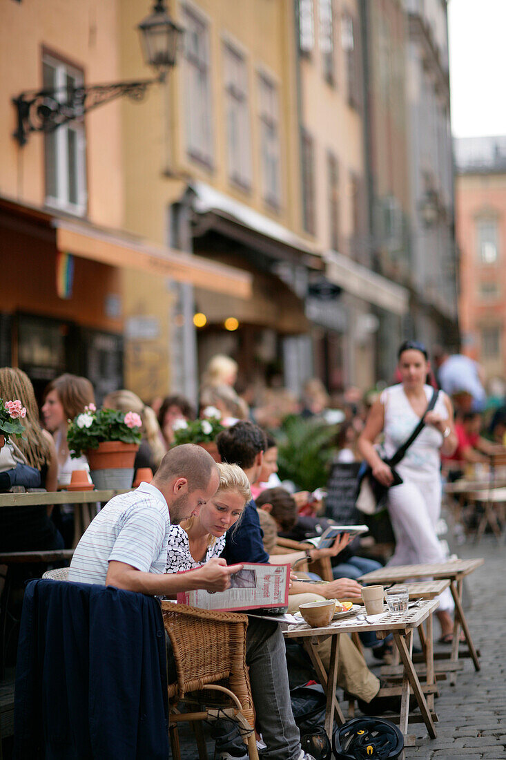 People eating out in a street restaurant, Gamla Stan Old Town, Stockholm, Sweden