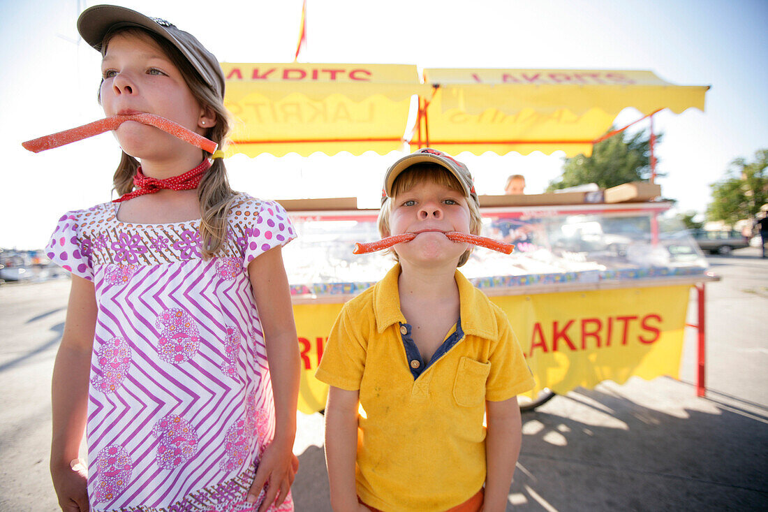 Boy and girl eating candy, typical liquorice, Visby, Gotland, Sweden