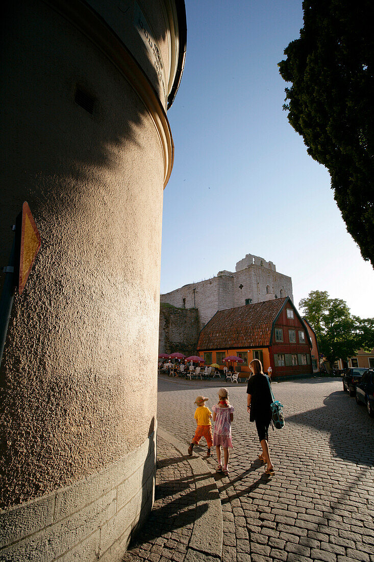 A mother and two children, pedestrians, walking through the old town, Visby, Gotland, Sweden