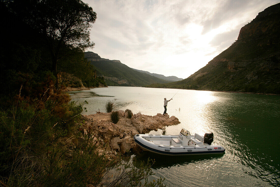 Man fishing from small island on a reservoir, lake, Valencia region, Spain